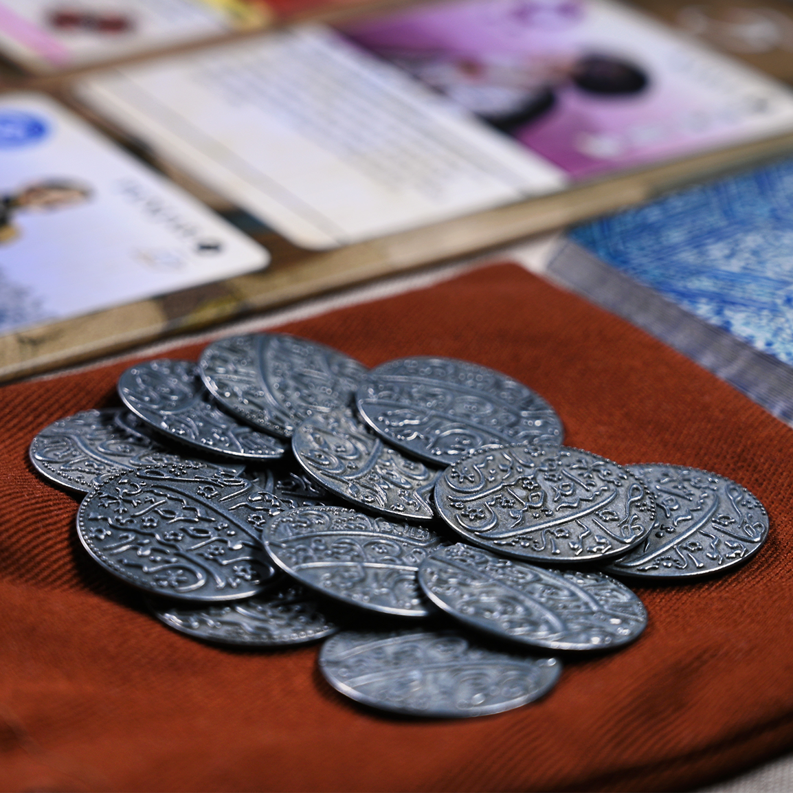A close-up of the metal coins add-on for Pax Pamir.